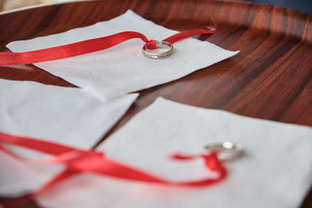 Engagement rings tied with red ribbonの写真素材