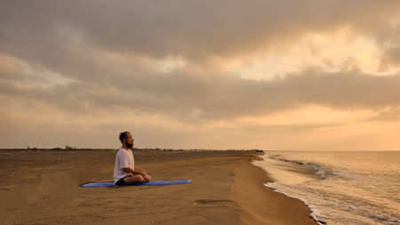 Portrait of man meditating at beachの写真素材