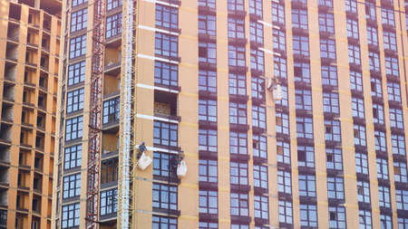 Industrial alpinists work at residential building under construction