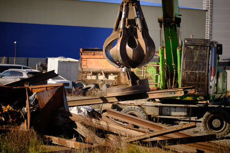 Crane moves metal rails at junkyard