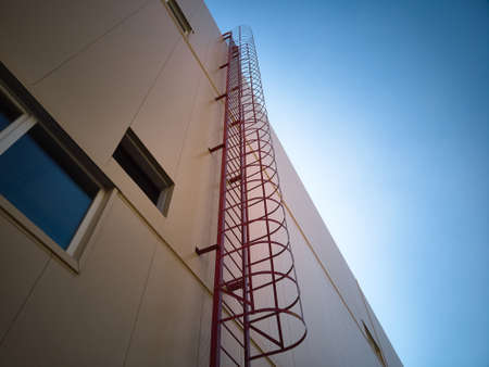 Outdoor fire escape ladder on industrial building wall