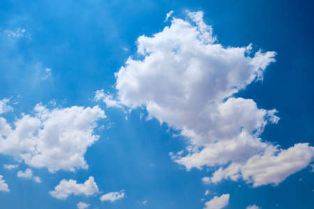 Cumulus clouds against bright blue sky