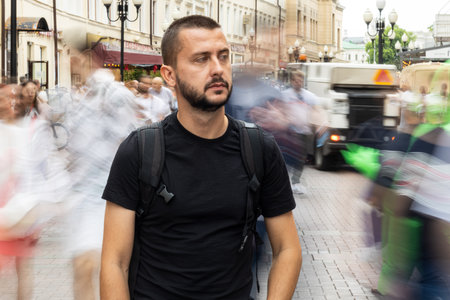 Sad young adult caucasian man in a crowd