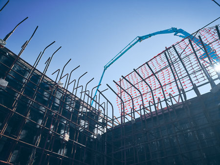 Arm of concrete pump ready for concrete conveying at construction site. Jib of concrete pump truck against sky at background. Truck mounted concrete pump ready for cement castingの写真素材