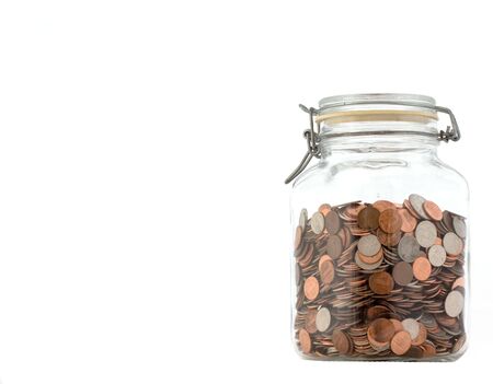closed glass jar of assorted coins, against a white background
