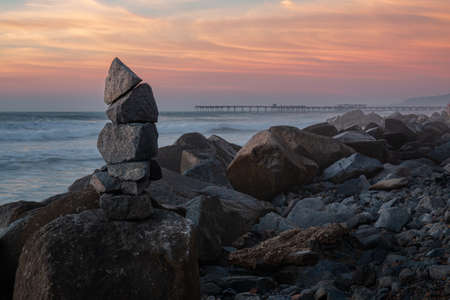 Stack of balanced rocks on the coastline of a beautiful sunset sky in San Diego, Californiaの写真素材