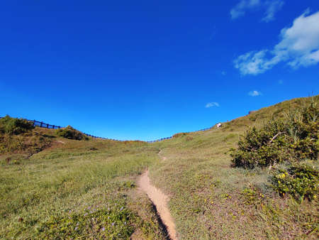 The view of the trail on the hill with the blue sky