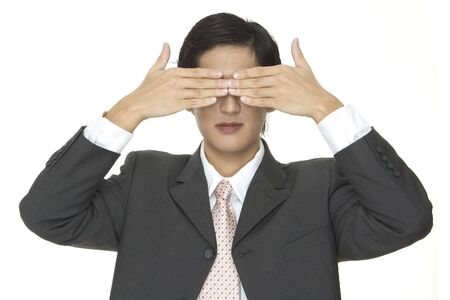 An asian businessman covers his eyes with his handsの写真素材