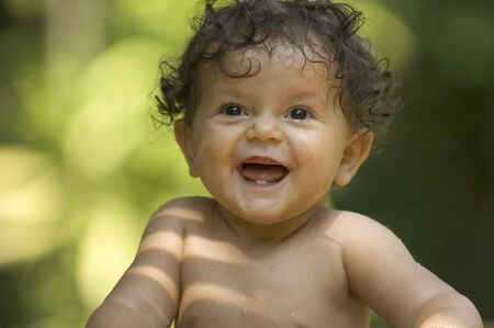 A toddler enjoys bath time in the tropical gardenの写真素材