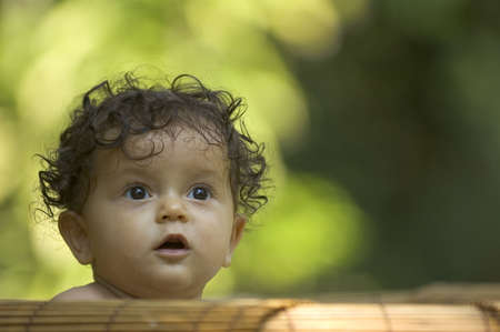 A toddler enjoys bath time in the tropical gardenの写真素材