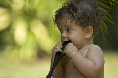 A toddler enjoys bath time in the tropical gardenの写真素材