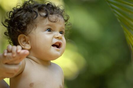 An infant enjoying bathtime in the tropical gardenの写真素材