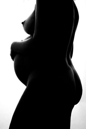A silhouette of a nude pregnant womanの写真素材