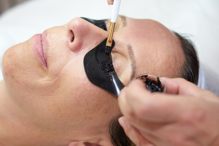 cosmetician painting eyelashes with brushの写真素材