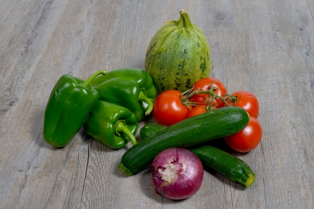 assortment of seasonal vegetables consisting of onions, zucchini, peppers, tomatoes and cucumberの写真素材