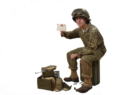 young American soldier in camouflage uniform shows a photographの写真素材