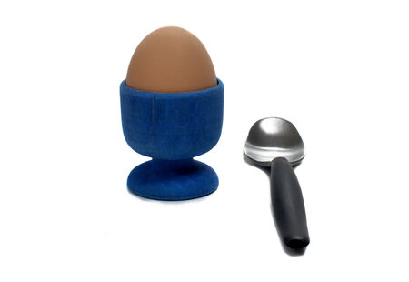 boiled egg in an egg cup with a small spoonの写真素材