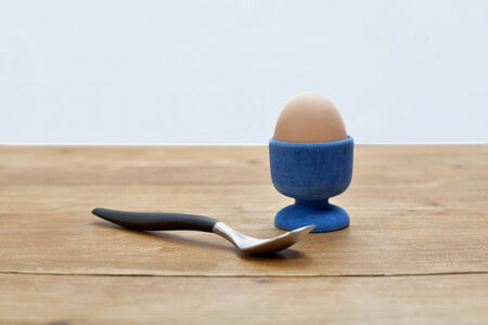 boiled egg in an egg cup with a small spoonの写真素材