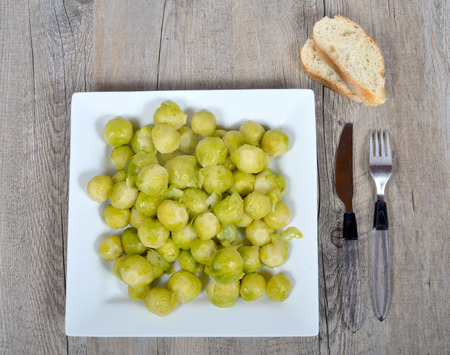 plate of brussels sprouts on the wood table with breadの写真素材