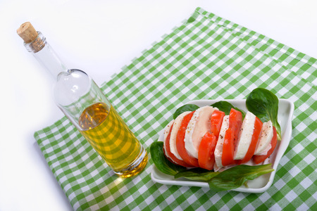 tomato salad with bottle of olive oil on the green towelの写真素材