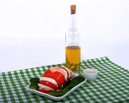 tomato salad with bottle of olive oil on the green towelの写真素材