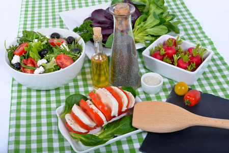 differents  salads with bottle of oil ,salt and pepper on the green towelの写真素材