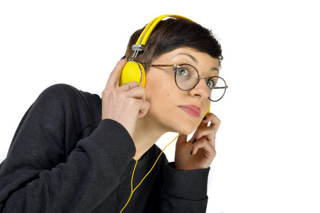 Young Woman wearing yellow headphones listening to musicの写真素材