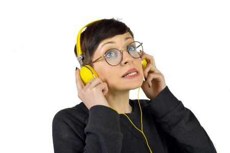Young Woman wearing yellow headphones listening to music