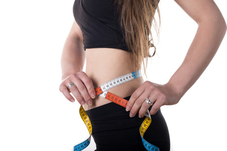 Woman measuring her waist with tape measureの写真素材