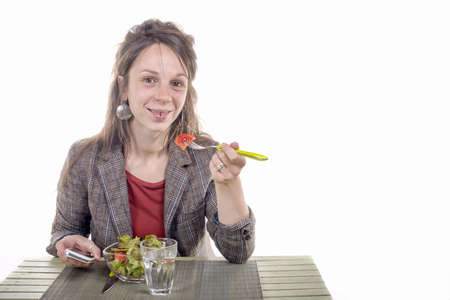 Portrait of a beautiful business woman eating vegetable salad. White background.の写真素材