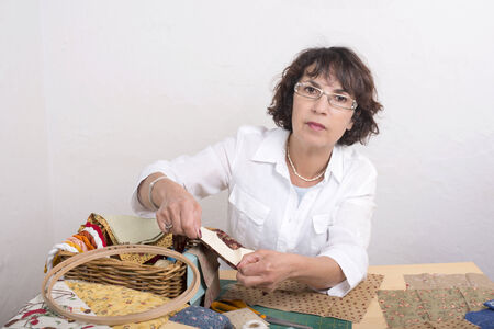 Mature woman by sewing and quilting in her home