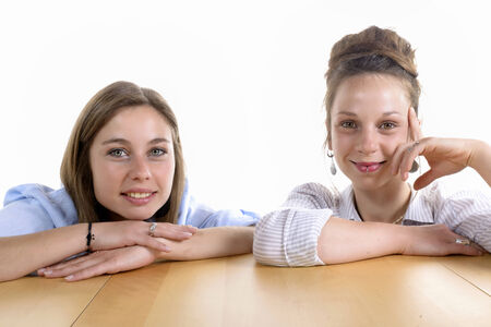 two pretty women staring at camera on the white backgroundの写真素材
