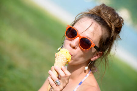 young woman with sunglasses eating ice creamの写真素材