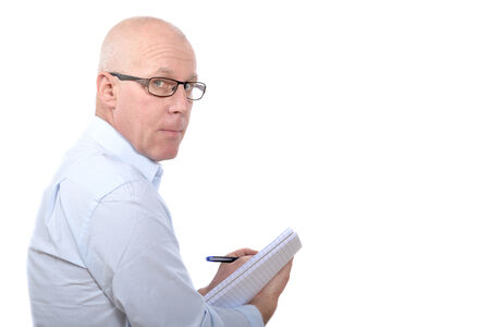 Man standing in blue shirt with a notebook in handsの写真素材