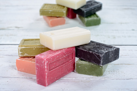 several multicolored soaps placed on a white wooden tableの写真素材
