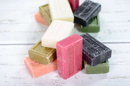 several multicolored soap placed on an old wooden tableの写真素材