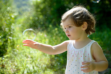a little girl playing with soap bubblesの写真素材