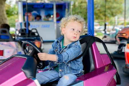 a little boy driving a bumper car at the carnivalの写真素材