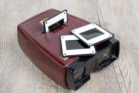 A Few viewer slides with old slides on the wooden table