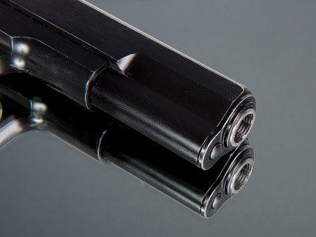 close up on the muzzle of a airsoft gun set on a mirror