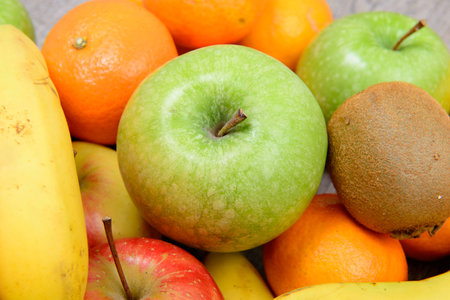 close up of various seasonal fruit with oranges, bananas, apples and kiwisの写真素材