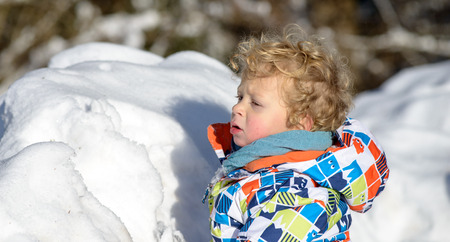 little 3 year old child playing in the snowの写真素材