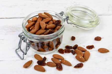 almonds with dry grapes in a glass jarの写真素材