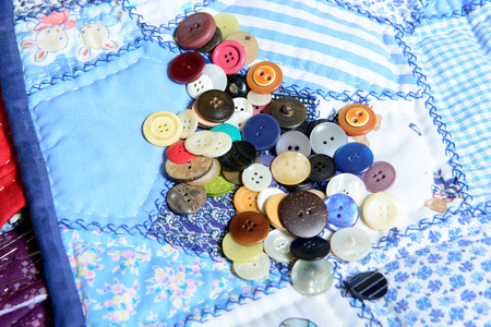 lot of buttons placed on a  blue quilting