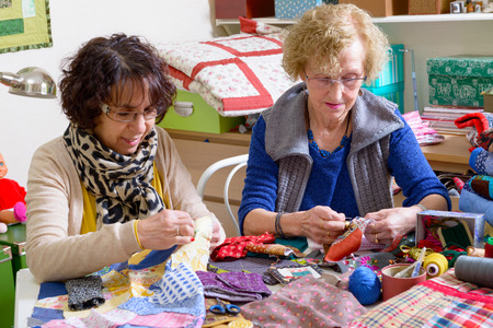two women working on their patchwork in the workshopの写真素材