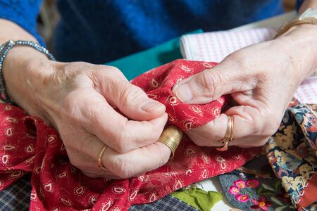 close-up of the hands of a seamstress in her officeの写真素材