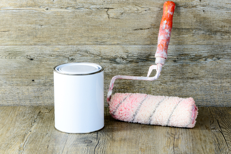 Roller and paint pot on a wooden tableの写真素材