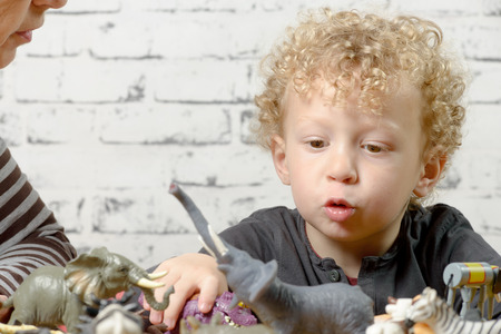 a little child plays with toys animalsの写真素材