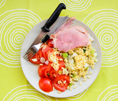 plate of raw vegetables with ham on a light green backgroundの写真素材