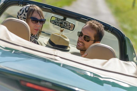 a young couple in a  green convertible car